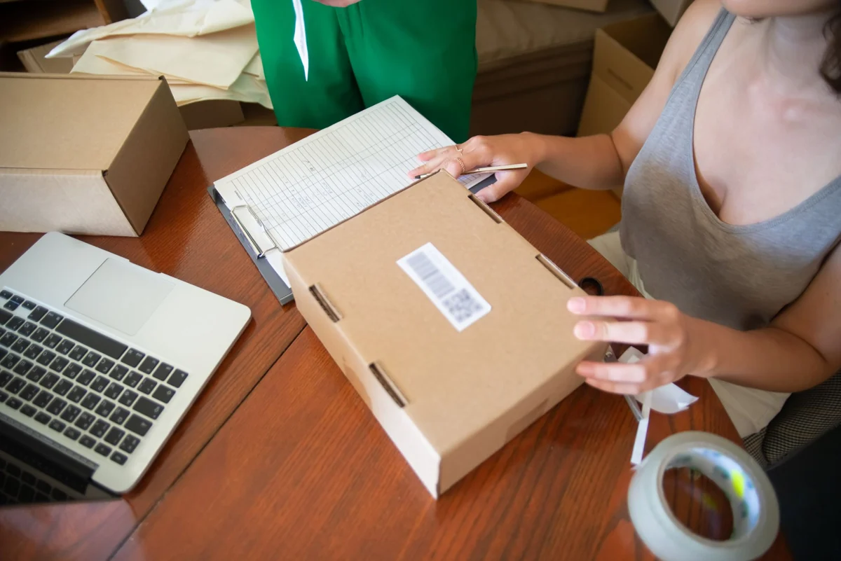 Preparing an online order with a parcel and laptop